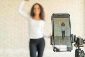 latijnse vrouw heeft haar dansvideo gemaakt met een smartphonecamera. om video te delen met een toepassing voor sociale media. foto