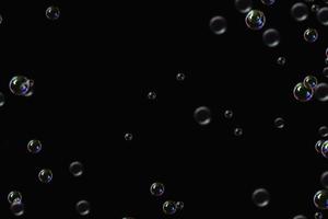 transparante bubbels zeep patroon overlay abstracte deeltjes spatten van water op zwart. foto