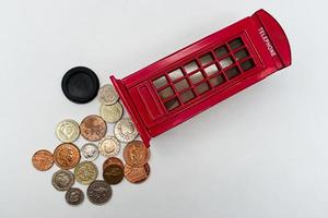 Britse spaarvarken met een groep Britse munten geïsoleerd op een witte achtergrond foto