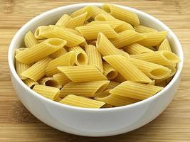 rauwe penne rigate pasta in een kom. traditionele italiaanse pasta. foto