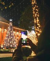 vrouw gebruikt mobiele telefoon en maakt foto's op vakantie in kerstmis