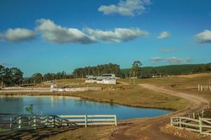 mooie boerderij met hekken, veestallen en blauw meer op landschap van landelijke laaglanden genaamd pampa's in cambara do sul. een klein stadje in het zuiden van Brazilië met verbazingwekkende natuurlijke toeristische attracties. foto