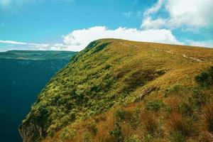 rotsachtig pad omhoog door droge struiken naar een klif bovenop de Fortaleza-kloof op een zonnige dag in de buurt van cambara do sul. een klein stadje in het zuiden van Brazilië met verbazingwekkende natuurlijke toeristische attracties. foto