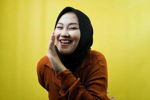 mooie jonge aziatische moslimvrouw die fluistert, geheimen vertelt, stil spreekt, stil, zelfverzekerd en opgewonden glimlacht, geïsoleerd