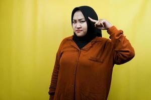 mooie jonge aziatische moslimvrouw die met de vinger naar het hoofd wijst, slim denkt, geïsoleerd foto