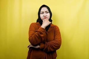 mooie jonge Aziatische moslimvrouw denken, kijken naar lege ruimte, op zoek naar geïsoleerde ideeën foto