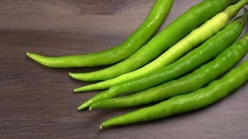 verse lange Indiase groene pepers op houten achtergrond. foto