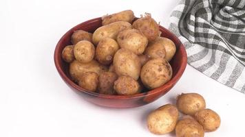 verse kleine aardappelen voor het koken in een houten kom. met kopie ruimte op een witte achtergrond. foto