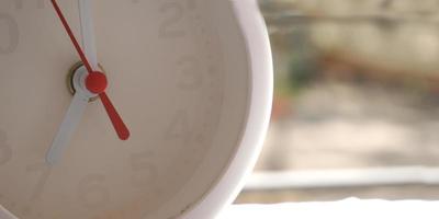 een close-up shot van een witte klok met pijlen die de tijd weergeven. foto