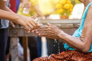 water gieten op de handen van gerespecteerde oudsten en om zegen vragen, gelukkig voor het songkran-festival in thailand, traditioneel thailand nieuwjaar. foto