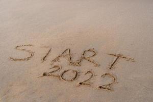 start en ga 2022 op het zand op het strand om volgend jaar het leven te laten zien. achtergrond foto