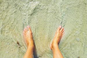 voeten in water en zandstrand playa del carmen mexico. foto