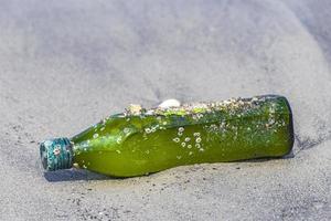 plastic fles strandde aangespoelde afvalvervuiling op het strand van brazilië.