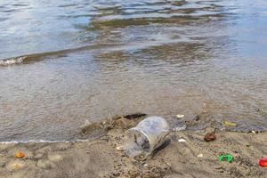 plastic fles strandde aangespoelde afvalvervuiling op het strand van brazilië.