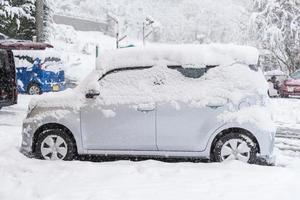 verse witte sneeuw die valt op de weg en auto van het openbare park in het winterseizoen in kawaguchiko, japan. foto