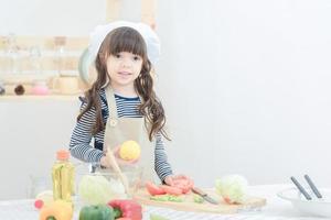 schattig meisje bereiden gezonde voeding salade in keuken room.photo ontwerp voor familie, kinderen en gelukkige mensen concept. foto