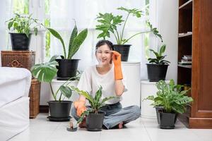de vrouw droeg oranje handschoenen en plantte bomen in het huis. foto