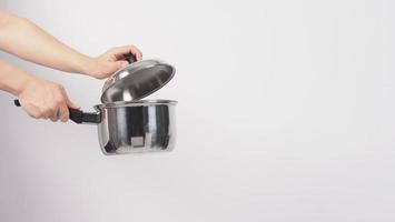 potten schoonmaken. man hand op witte achtergrond die de non-stick pot schoonmaakt foto