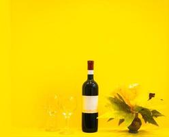 wijn met glazen op gele achtergrond foto