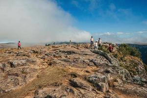 cambara do sul, brazilië - 18 juli 2019. mensen op de top van de klif bij fortaleza canyon met rotsachtig landschap en wolken in de buurt van cambara do sul. een klein landelijk stadje met verbazingwekkende natuurlijke toeristische attracties. foto