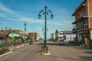 cambara do sul, brazilië - 19 juli 2019. flamboyante lichtmasten en huizen met winkel aan de getulio vargas-laan in cambara do sul. een klein landelijk stadje met verbazingwekkende natuurlijke toeristische attracties. foto