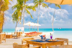 luxe resorthotel aan het zwembad, openluchtrestaurant op het strand, de oceaan en de lucht, tropisch eilandcafé, tafels, eten. zomervakantie of vakantie, familie reizen. palmbomen, overloopzwembad, cocktails, relax