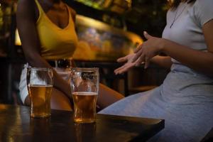 vrouwen zitten aan tafel in pub praten. niet-herkende mensen foto