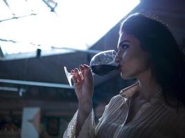 meisje dat rode wijn drinkt uit een glas foto