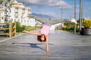 zwarte fitte vrouw die fitnessacrobatiek doet op stedelijke achtergrond foto