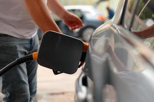 hand man bijvullen en vullen van olie gas brandstof op station. foto