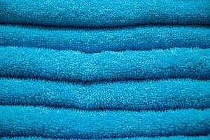 textuur van blauwe badstof handdoek. een stapel zachte badaccessoires. foto