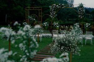 ceremonie, boog, huwelijksboog, huwelijk, huwelijksmoment, decoraties, decor, huwelijksdecoraties, bloemen, stoelen, buitenceremonie in de open lucht, boeketten bloemen foto