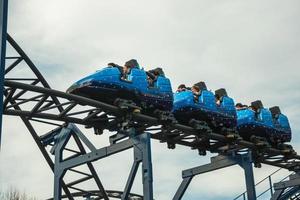 canela, brazilië - 21 juli 2019. mensen in een blauwe kar die plezier hebben op de achtbaan op een bewolkte dag in het alpen-pretpark in de buurt van canela. een charmant stadje dat erg populair is vanwege zijn ecotoerisme. foto