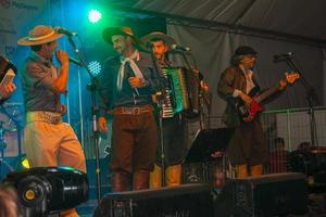 canela, brazilië - 21 juli 2019. muzikanten die typische kleding dragen en traditionele liederen uitvoeren op het podium van een folkloristisch festival in canela. een charmant stadje dat erg populair is vanwege zijn ecotoerisme. foto