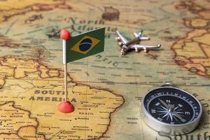 vlag van brazilië, kompas en vliegtuig op de wereldkaart. foto