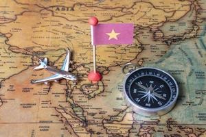 vietnam vlag, kompas en vliegtuig op de wereldkaart. foto