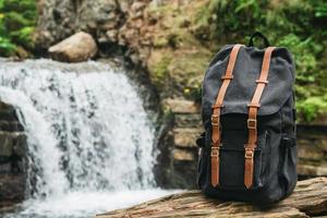 rugzaktoerisme op achtergrond van rivier en waterval foto