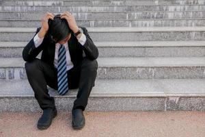 Aziatische zakenlieden met hoofdpijn of migraine op het stadhuis na het werk beelden van jonge zakenlieden die moe zijn, stress, crisis, depressie, mislukking in bedrijfsconcepten foto
