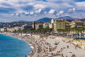 nice, frankrijk, 2019 - niet-geïdentificeerde mensen op het strand en de promenade des anglais aan de franse riviera in nice, frankrijk. in nie zijn er 15 particuliere en 20 openbare stranden. foto