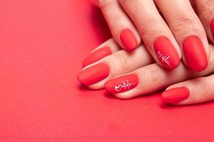 rode matte manicure op vrouwelijke handen voor Valentijnsdag foto