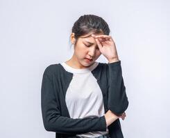 een zieke vrouw met hoofdpijn en legde haar hand op haar hoofd foto