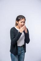 een vrouw hoest en bedekt haar mond met haar hand foto