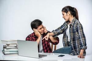 vrouwen leren mannen werken met laptops op het werk. foto