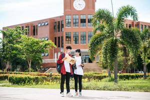 mannelijke en vrouwelijke studenten dragen een koel gezicht en staan voor de universiteit. foto
