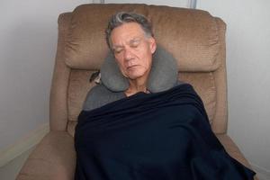 volwassen man die midden op de dag een dutje doet in een luie stoel foto
