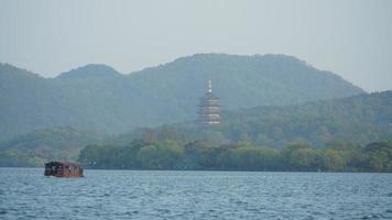 de prachtige meerlandschappen in de Chinese stad Hangzhou in het voorjaar met een oude tempeltoren aan de kust foto