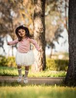klein meisje dat in een park springt foto