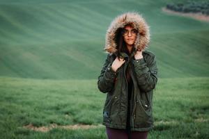 portret van een vrouw die het koud heeft in de winter op een groene weide foto