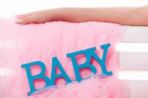 close-up van blue label baby voor pasgeboren, op roze. blauwe letters foto