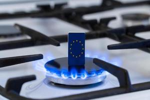tekort en gascrisis. vlag van de europese unie op een brandend gasfornuis foto